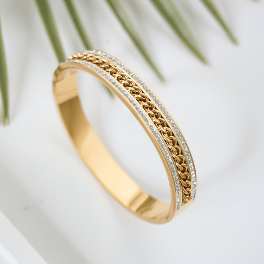 Gold bracelet with intricate design on a white background