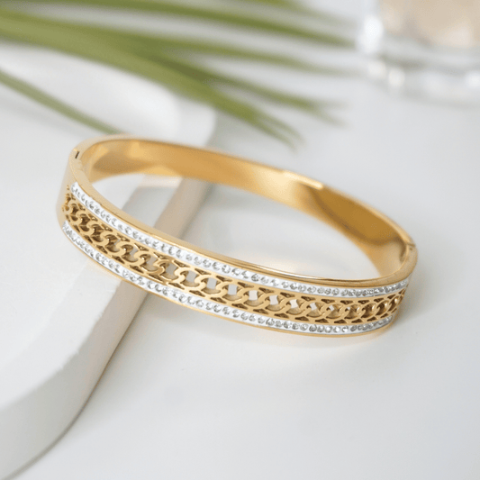 Gold bracelet with intricate design on a light background