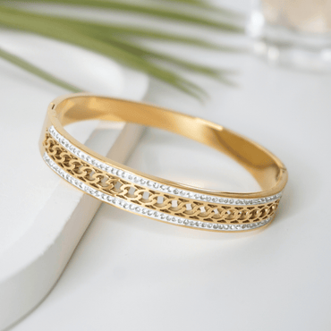 Gold bracelet with intricate design on a light background