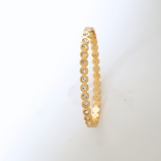Gold bracelet with embedded stones on a white background