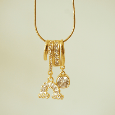 Gold necklace with a pendant on a light beige background