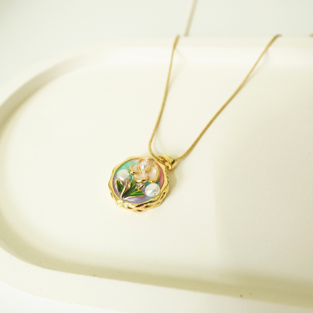 18K gold-plated floral pendant necklace featuring a pastel enamel background, delicate flower motif, and pearl accents — handcrafted waterproof jewelry for women.

