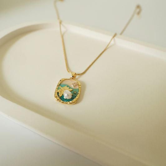 18K gold-plated necklace with a handcrafted ocean-inspired pendant featuring a pearl, leaf motif, and enamel detailing — waterproof and anti-tarnish designer jewelry.”
