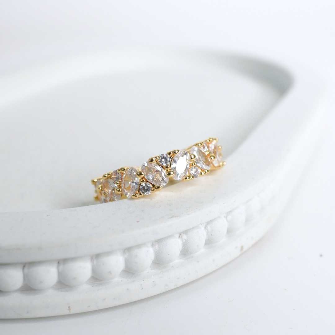 Gold ring with clear stones on a white surface