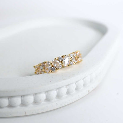 Gold ring with clear stones on a white surface