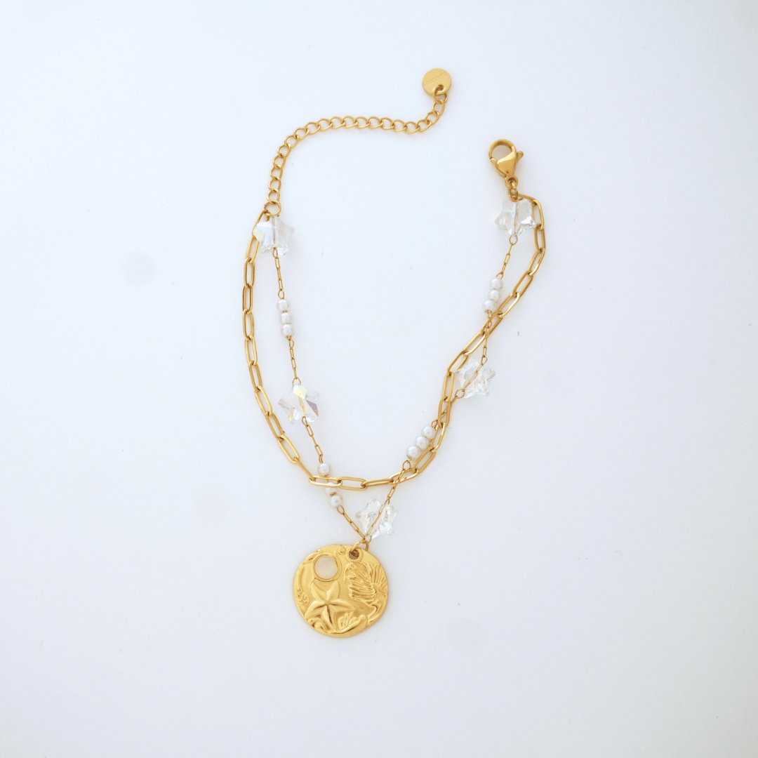Gold bracelet with a pendant on a white background