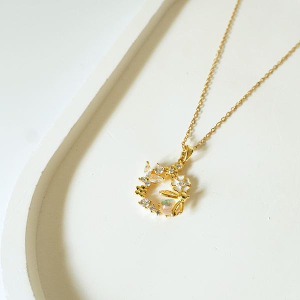 Floral 18k gold-plated dragonfly pendant necklace by Ashara Jewels placed on a neutral background”
